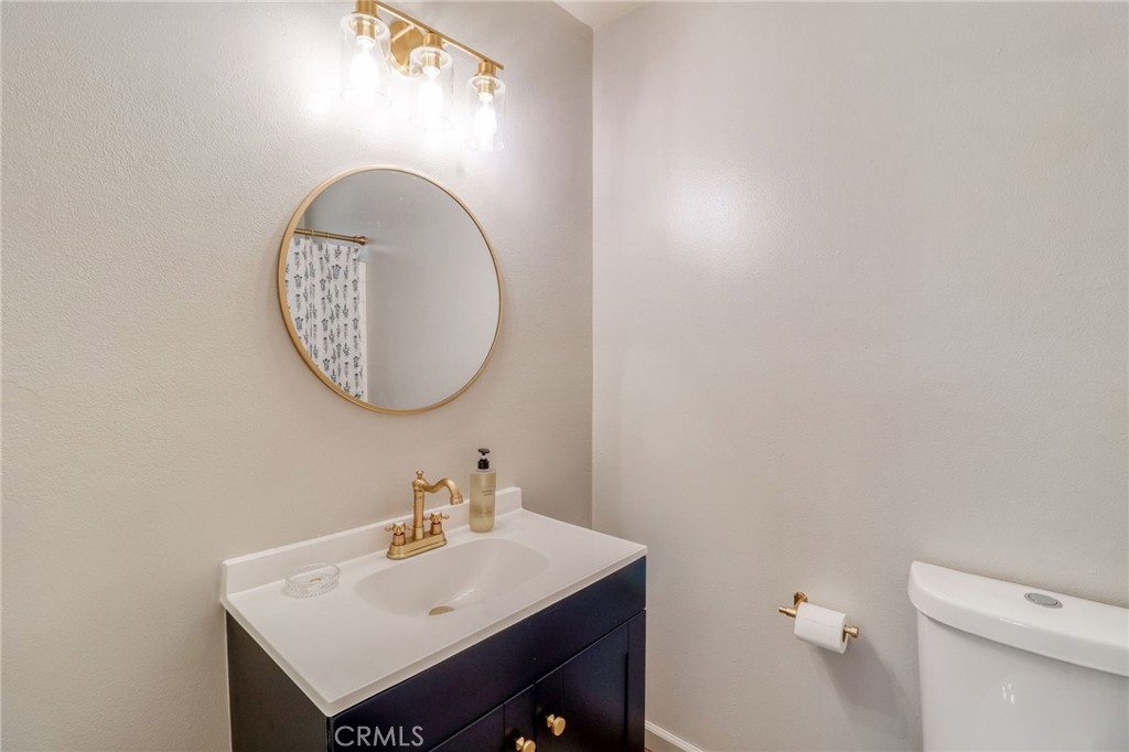 14235 Judy Ann Drive Riverside, CA 92503 - Photo 31 of 68 a bathroom with a sink a mirror and a toilet