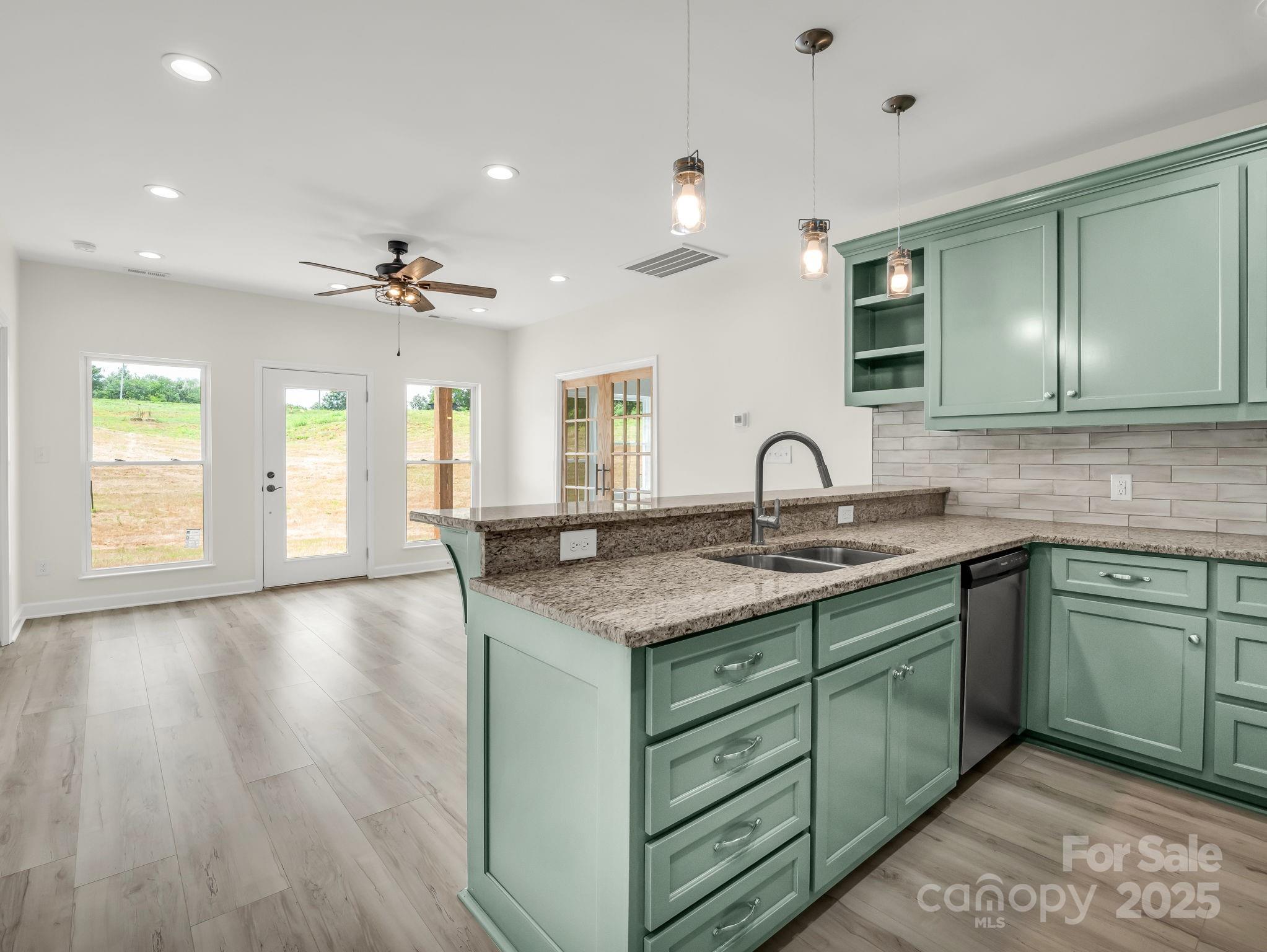 174 Charlie Randall Road Lawndale, NC 28090 - Photo 12 of 41 a kitchen with granite countertop a sink and dishwasher with wooden floor