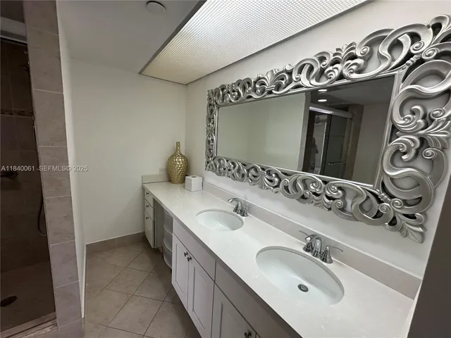 a bathroom with a shower sink and mirror