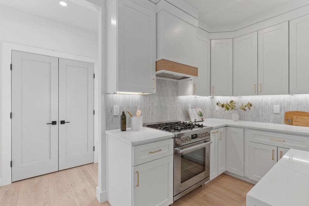 28 Sutherland Road, Unit 28 Arlington, MA 02476 - Photo 13 of 40 a kitchen with cabinets appliances and wooden floor