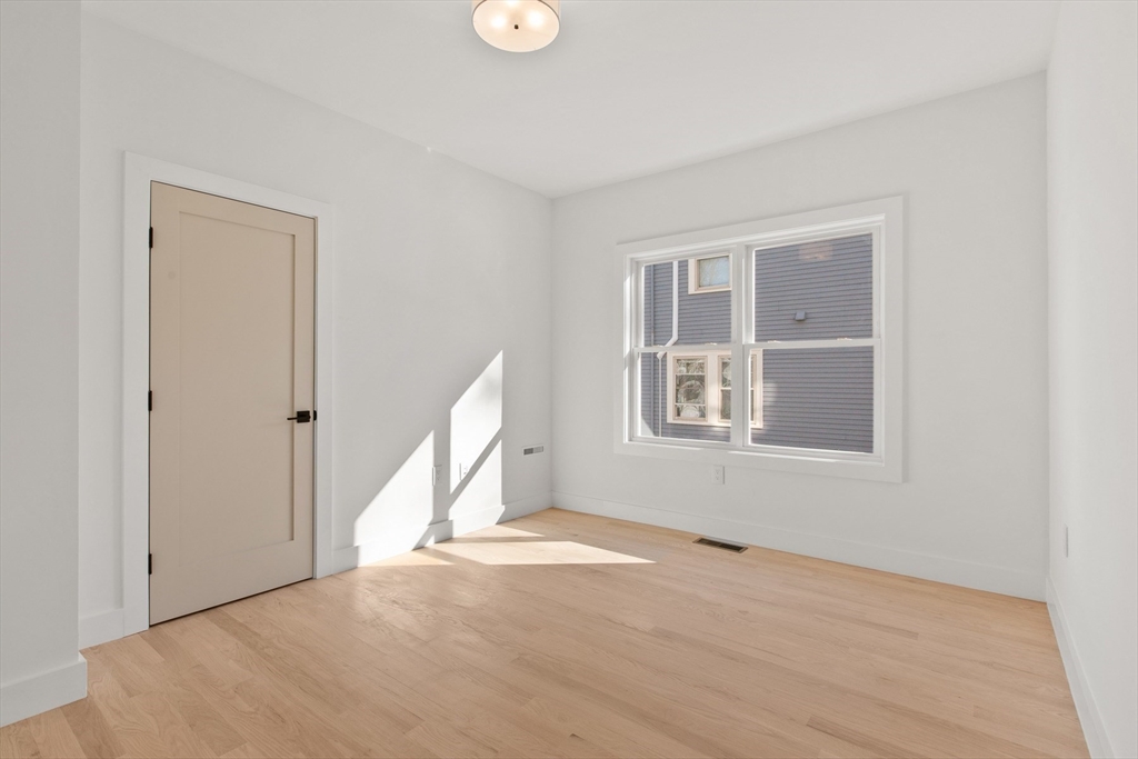 28 Sutherland Road, Unit 28 Arlington, MA 02476 - Photo 25 of 40 a view of an empty room with wooden floor and a window