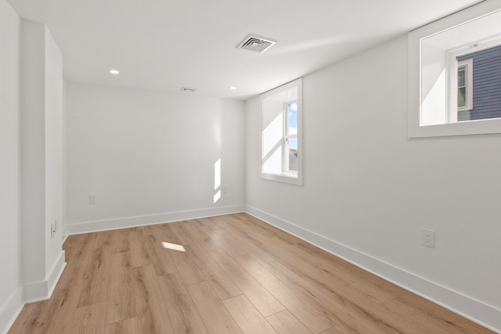 28 Sutherland Road, Unit 28 Arlington, MA 02476 - Photo 34 of 40 wooden floor in an empty room with a window