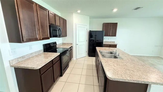 a view of kitchen with kitchen island cabinets and refrigerator