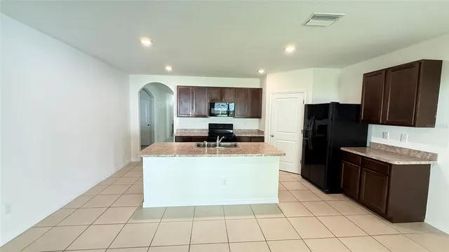 a kitchen with stainless steel appliances granite countertop a refrigerator sink and stove