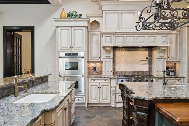 a kitchen with stainless steel appliances granite countertop a sink and a stove