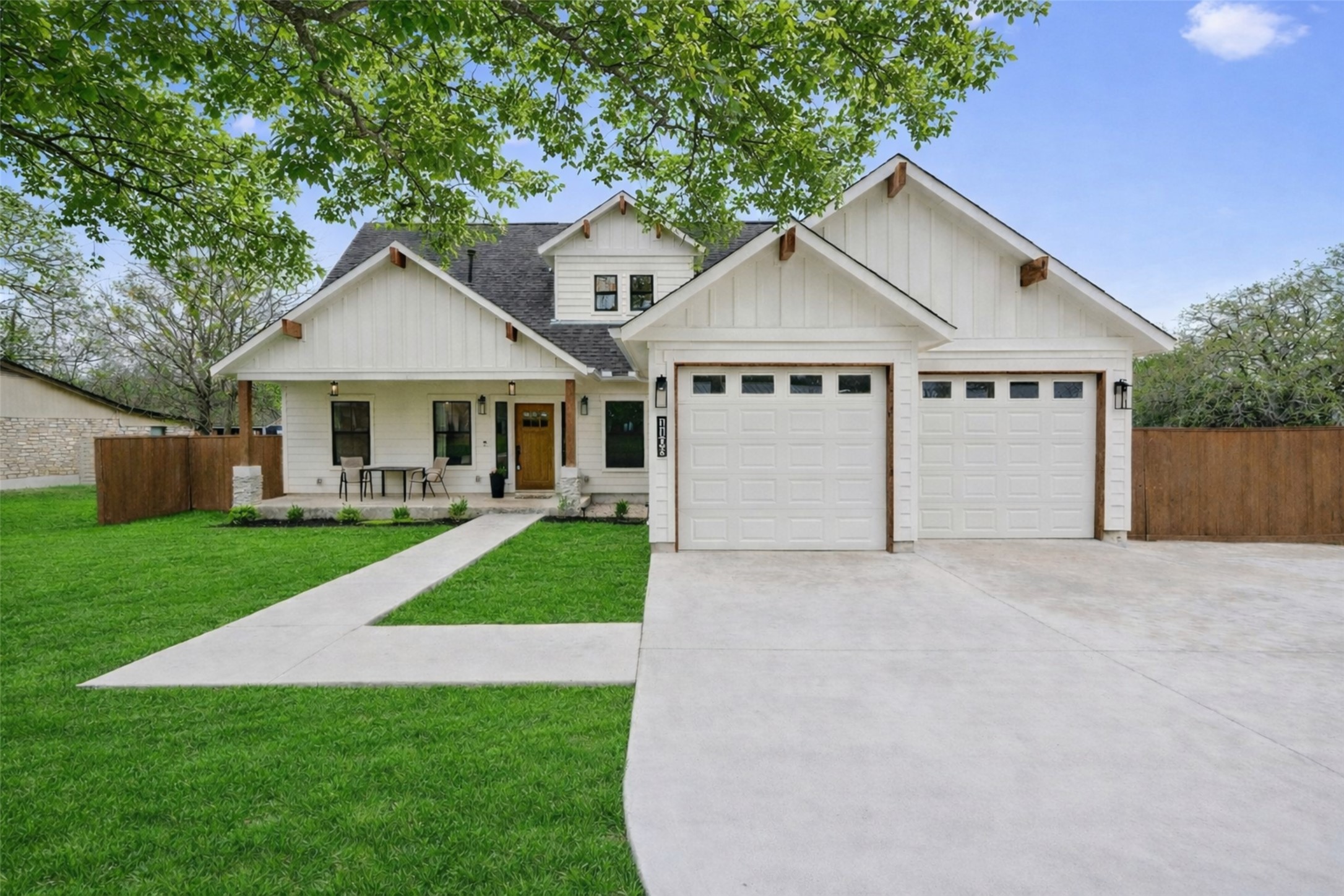 a view of a house with a yard and large tree