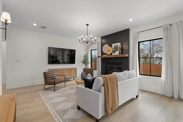 a living room with furniture a flat screen tv and a fireplace