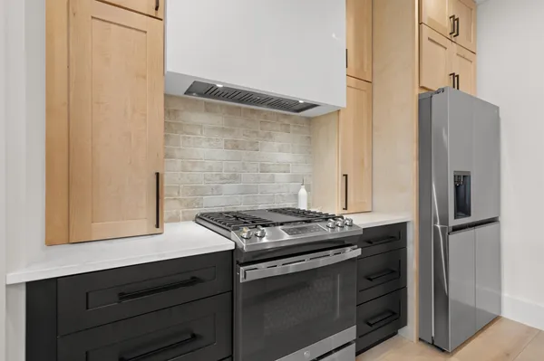 a kitchen with stainless steel appliances a stove and a refrigerator with white cabinets