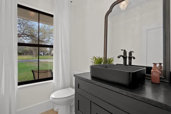 a bathroom with a sink a toilet and a mirror
