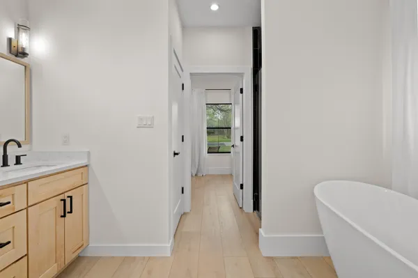 a bathroom with a tub sink and mirror