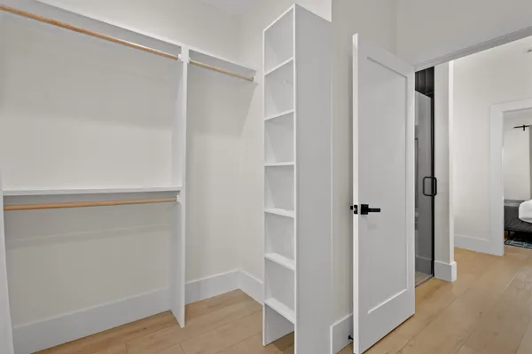a view of walk in closet with empty racks