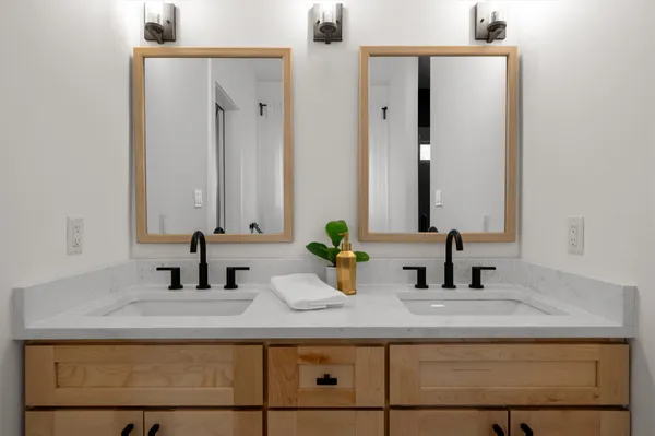 a bathroom with double vanity sinks and a mirror