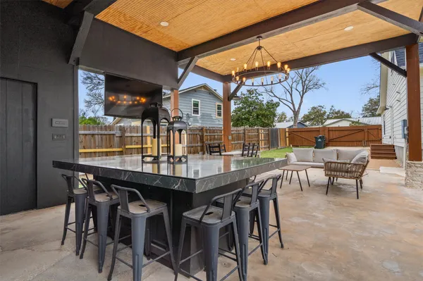 a kitchen with stainless steel appliances kitchen island granite countertop a table chairs in it and wooden floor