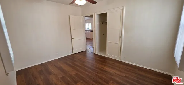 an empty room with wooden floor and closet area