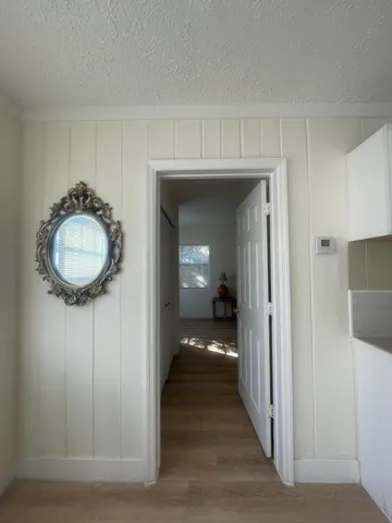 a view of a hallway with wooden floor and a chandelier