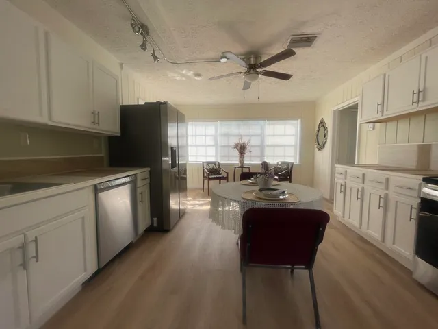 a kitchen with refrigerator cabinets and wooden floor