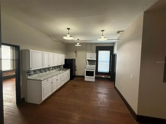 a view of a kitchen with cabinets and a stove
