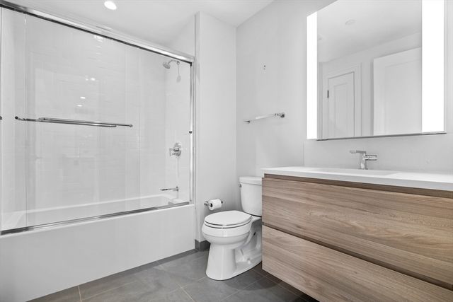 a bathroom with a sink a toilet and a large mirror