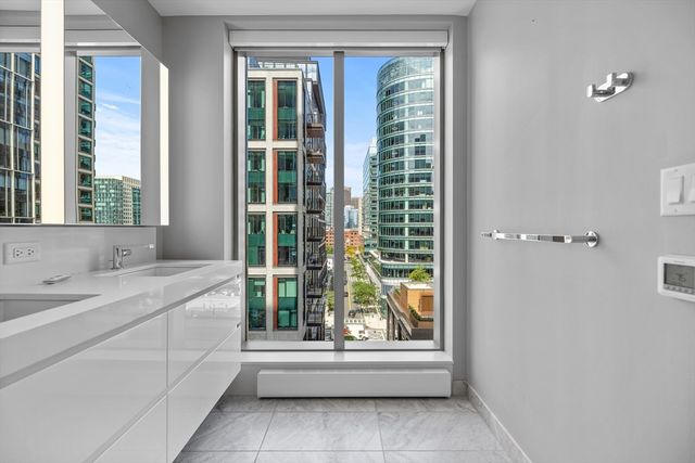 a bathroom with a granite countertop sink and a window