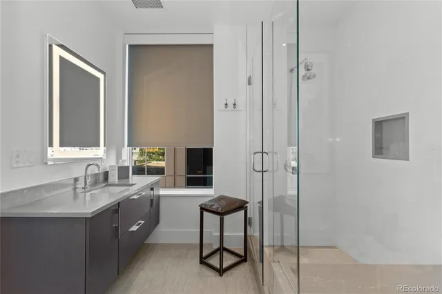 a bathroom with a double vanity sink a mirror and a shower