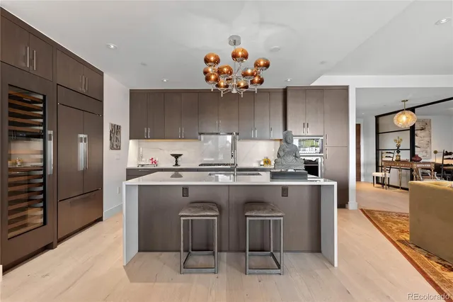 a kitchen with kitchen island granite countertop a sink stove and refrigerator
