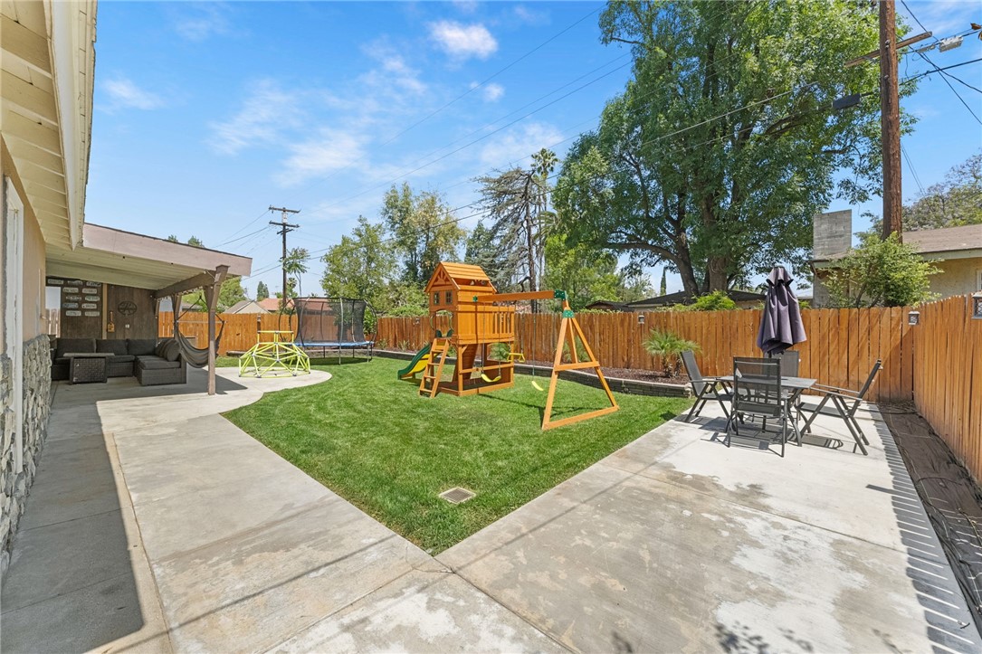 4869 Serrano Place Riverside, CA 92504 - Photo 39 of 40 Expansive backyard with open green space, play area, and multiple spaces for relaxing or entertaining.