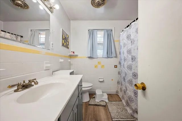 a bathroom with a sink a toilet and shower curtain