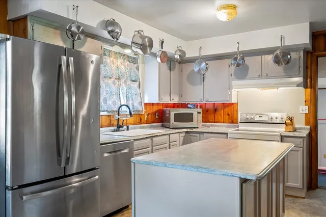 a kitchen with stainless steel appliances granite countertop a refrigerator and a sink