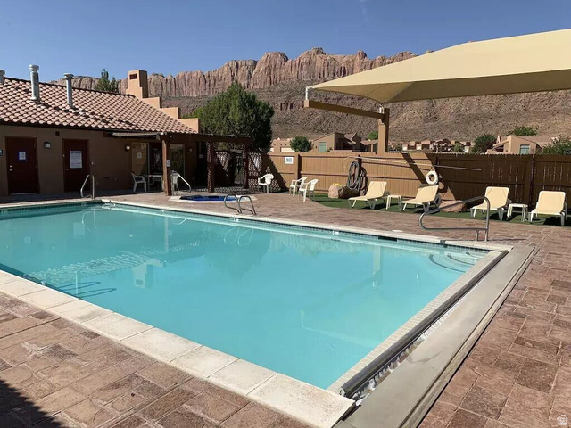 3853 South Red Valley Circle, Unit 22A1 Moab, UT 84532 - Photo 25 of 28 Community pool featuring a patio area, a pergola, and a mountain view