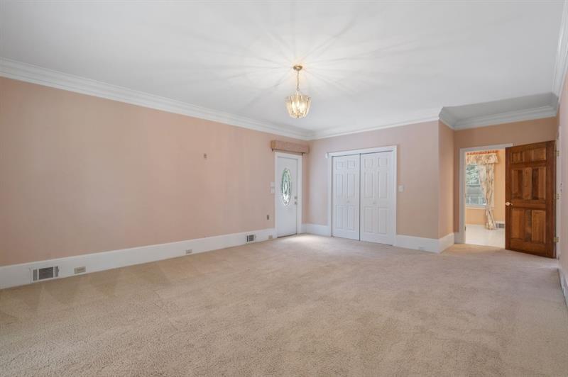 1120 Heards Ferry Road Northwest Sandy Springs, GA 30328 - Photo 19 of 50 an empty room with chandelier fan and windows
