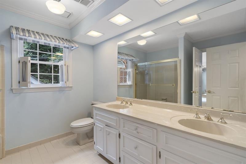 1120 Heards Ferry Road Northwest Sandy Springs, GA 30328 - Photo 29 of 50 a spacious bathroom with a granite countertop double vanity sink a mirror and a toilet