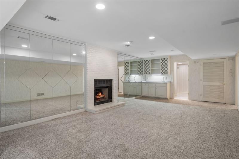 1120 Heards Ferry Road Northwest Sandy Springs, GA 30328 - Photo 32 of 50 an empty room with fireplace and windows