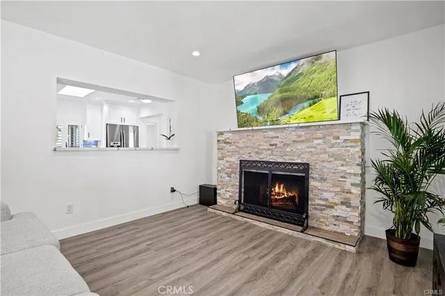 a living room with a fireplace and wooden floor