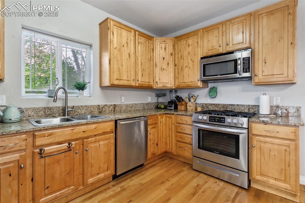 1502 York Road, Unit 103 Colorado Springs, CO 80920 - Photo 11 of 27 a kitchen with granite countertop white cabinets a sink and a oven