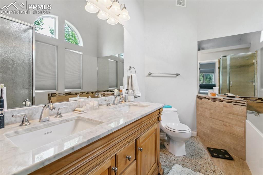 1502 York Road, Unit 103 Colorado Springs, CO 80920 - Photo 15 of 27 a bathroom with a granite countertop double vanity sink a mirror and toilet