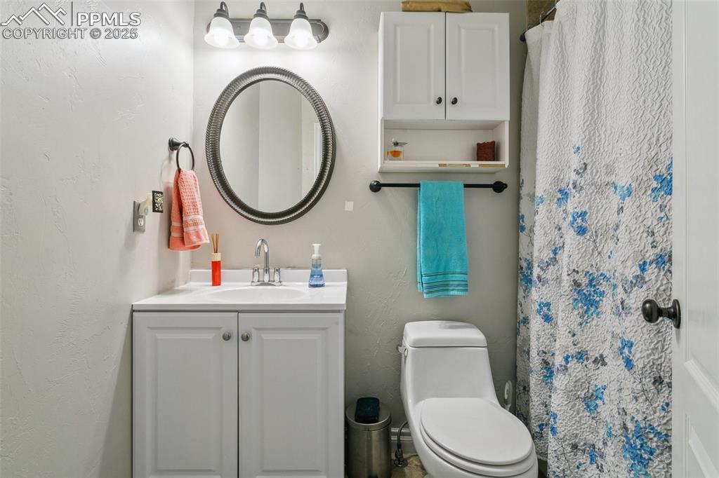 1502 York Road, Unit 103 Colorado Springs, CO 80920 - Photo 19 of 27 a bathroom with a toilet a sink and a mirror