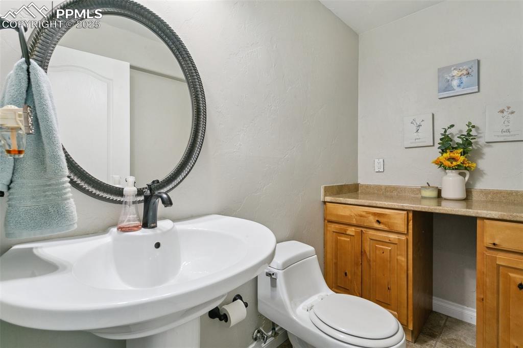 1502 York Road, Unit 103 Colorado Springs, CO 80920 - Photo 25 of 27 a bathroom with a sink a mirror and toilet