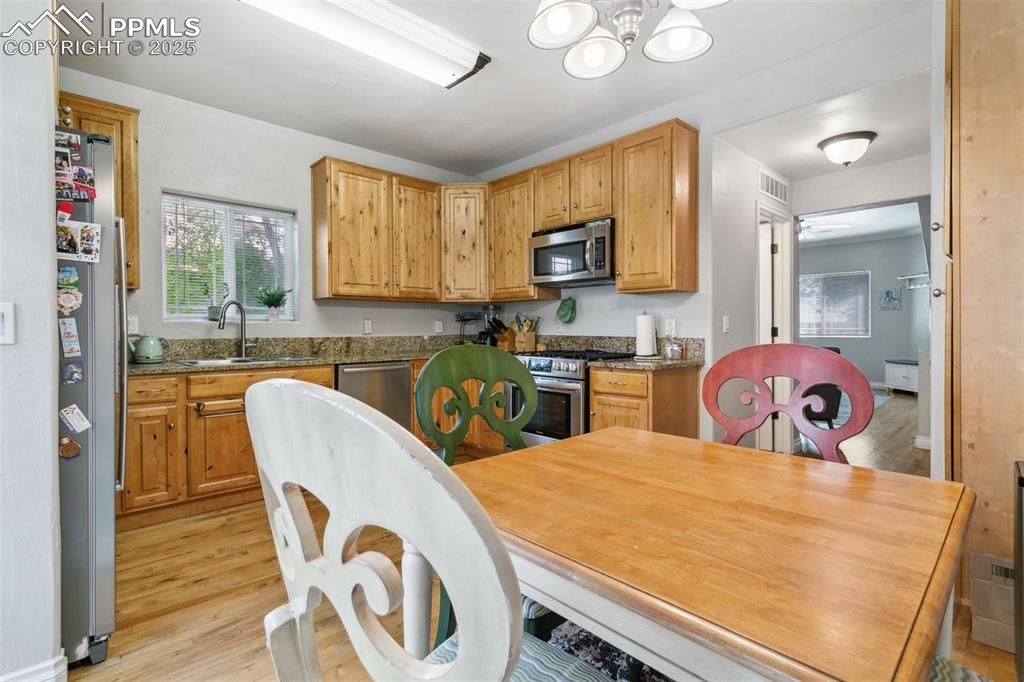 1502 York Road, Unit 103 Colorado Springs, CO 80920 - Photo 9 of 27 a kitchen with a table chairs and a refrigerator