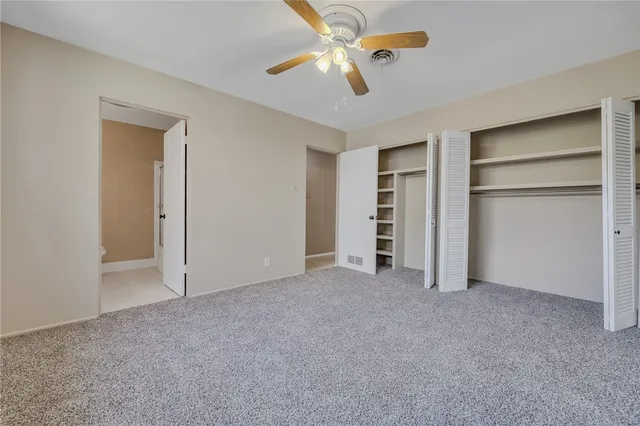 a view of an empty room with a chandelier fan