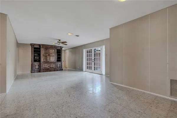 a view of an empty room with window and cabinet