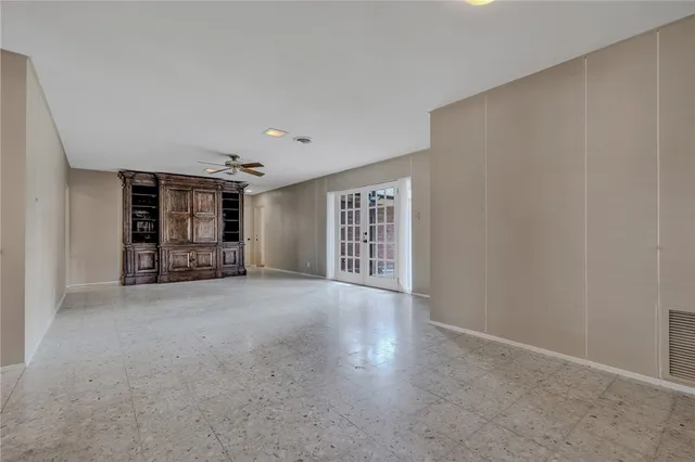 a view of an empty room with window and cabinet