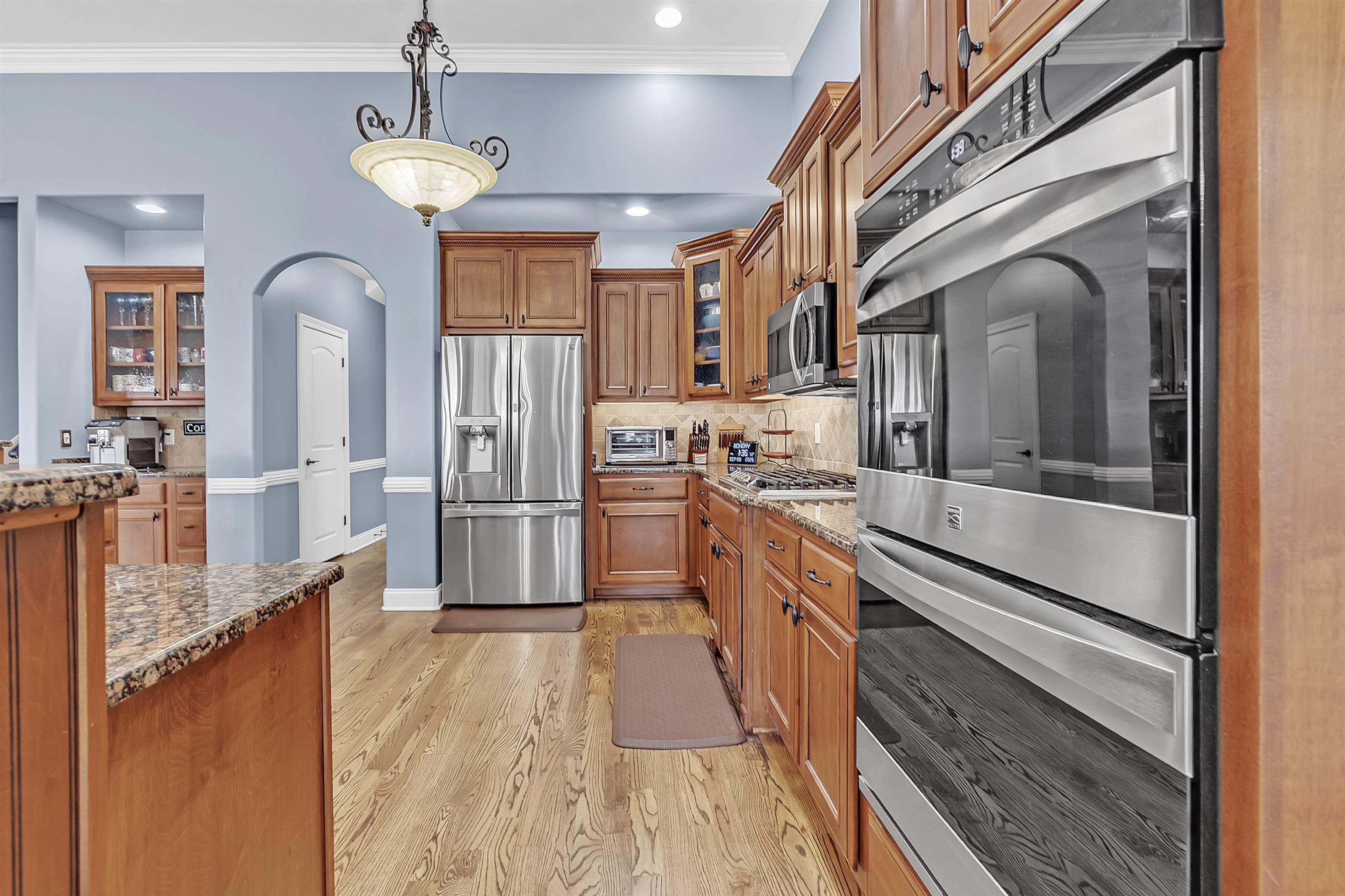 200 Misty Fields Road Oakland, TN 38060 - Photo 13 of 40 Kitchen with glass insert cabinets, stainless steel appliances, brown cabinets, arched walkways, and dark stone counters