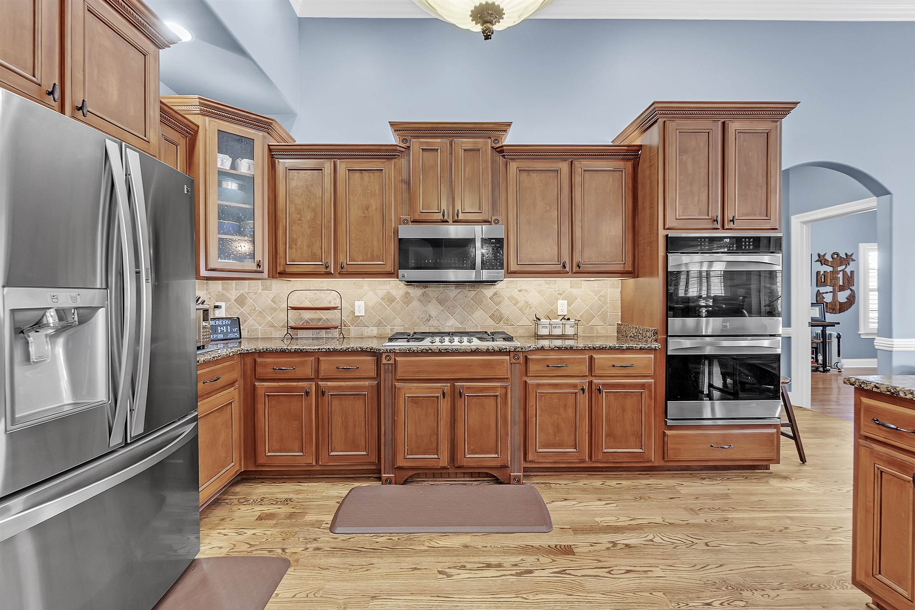 200 Misty Fields Road Oakland, TN 38060 - Photo 14 of 40 Kitchen featuring appliances with stainless steel finishes, brown cabinets, arched walkways, and dark stone counters