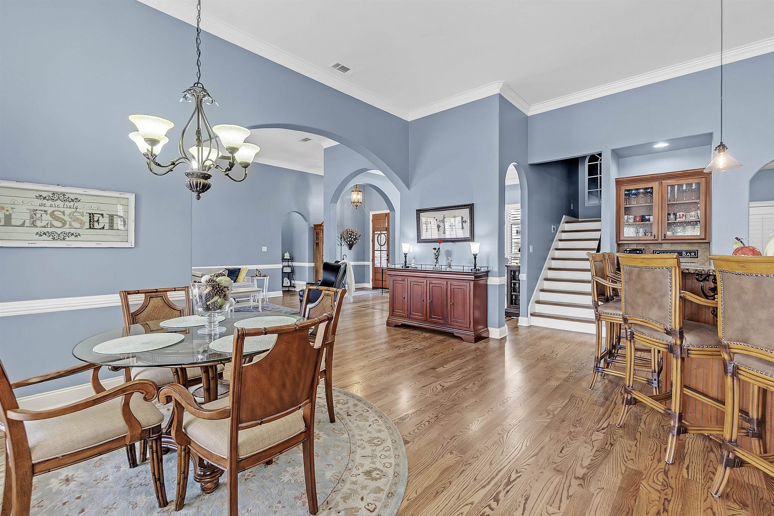 200 Misty Fields Road Oakland, TN 38060 - Photo 17 of 40 Dining room with arched walkways, crown molding, a chandelier, light wood-style flooring, and stairs