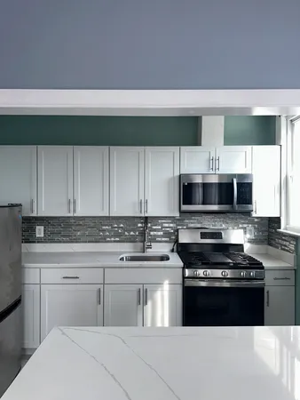 a kitchen with stainless steel appliances a stove sink and cabinets