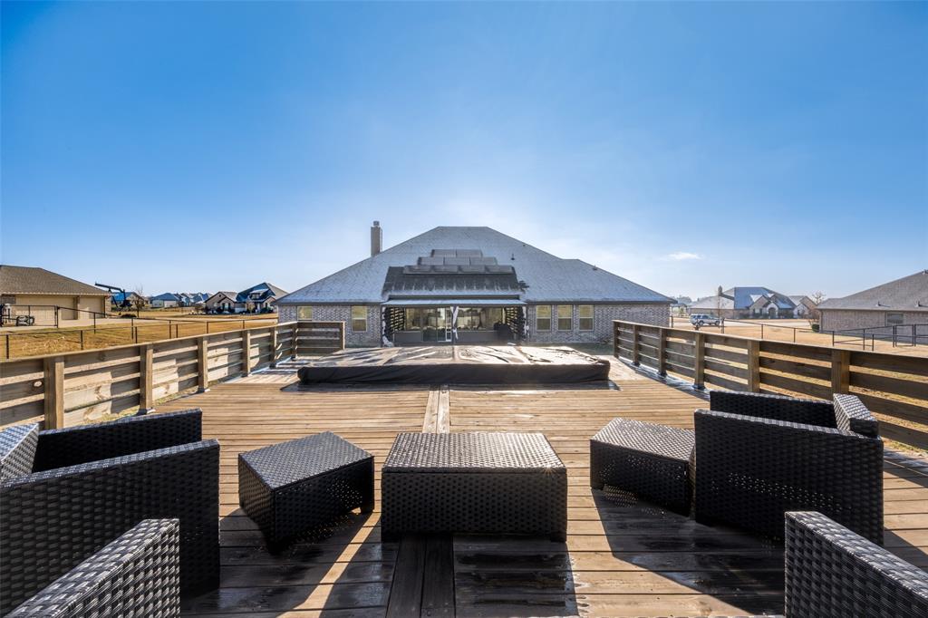 7417 Green Mesa Road Ponder, TX 76259 - Photo 37 of 39 a view of a roof deck with couches under an umbrella next to an ocean