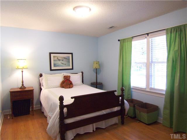 4920 Brookhurst Place Raleigh, NC 27609 - Photo 17 of 24 a bedroom with a bed a lamp and a window