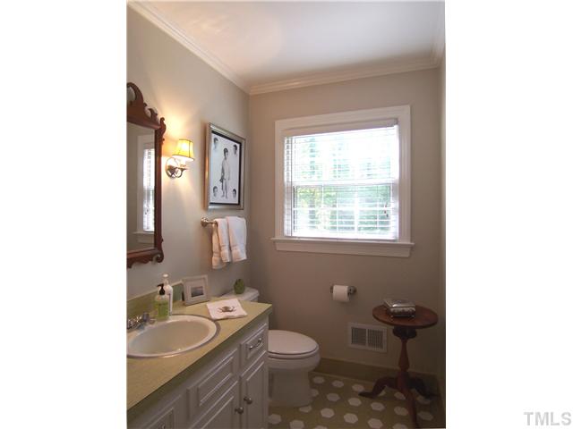 4920 Brookhurst Place Raleigh, NC 27609 - Photo 9 of 24 a bathroom with a granite countertop toilet a sink and mirror