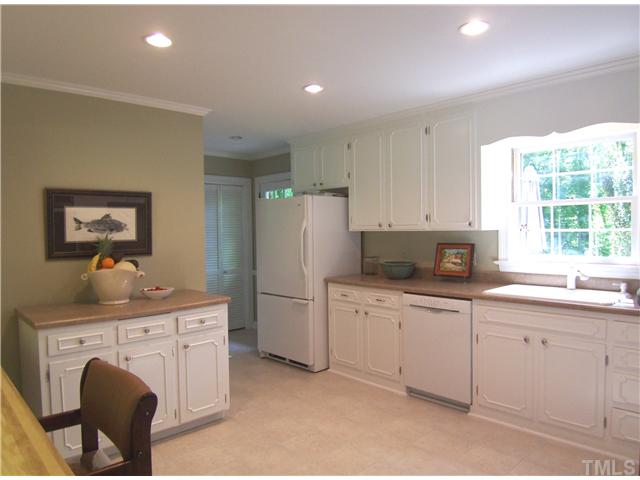 4920 Brookhurst Place Raleigh, NC 27609 - Photo 10 of 24 a kitchen with white cabinets a sink and appliances