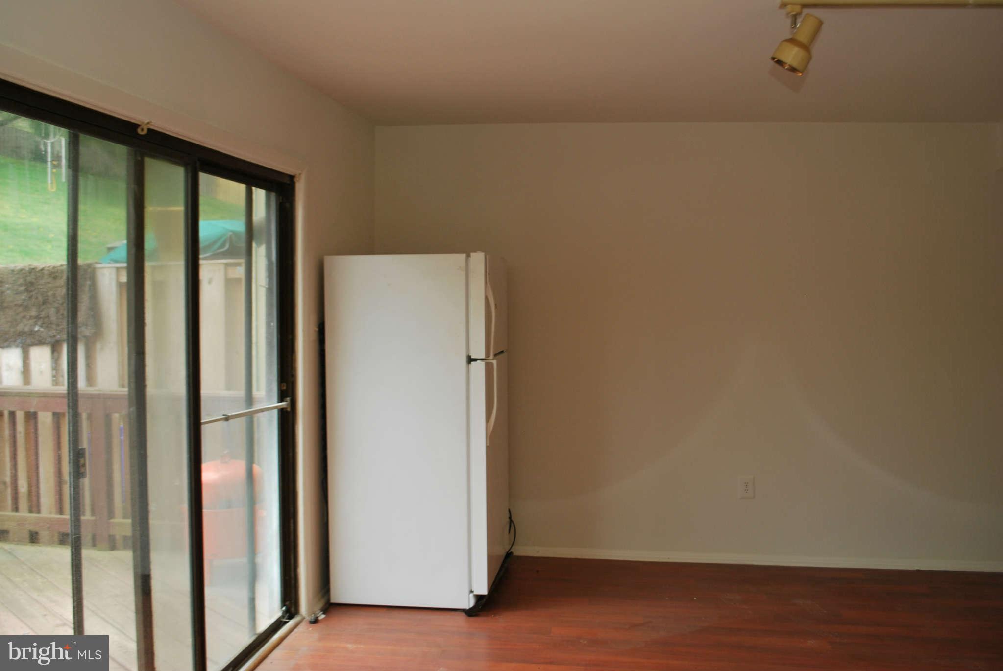 9116 Centerway Road Gaithersburg, MD 20879 - Photo 9 of 25 an empty room with wooden floor and windows